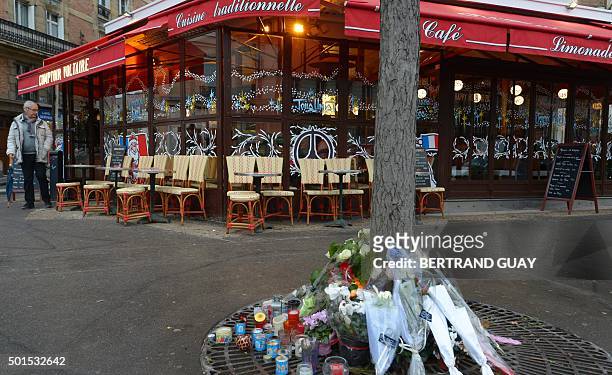 This picture shows candles and flowers in front of the brasserie Le Comptoir Voltaire near Place de la Nation in eastern Paris, on the day of its...