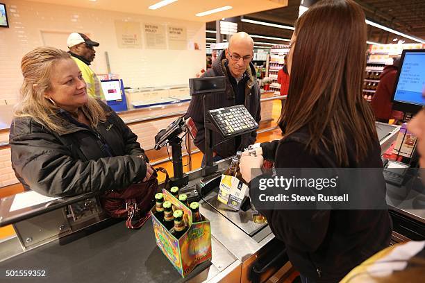 Carol and William Warner are a pair of the first to purchase beer. Three lanes at the Leslieville Loblawas are equipped to handle beer sales, the...