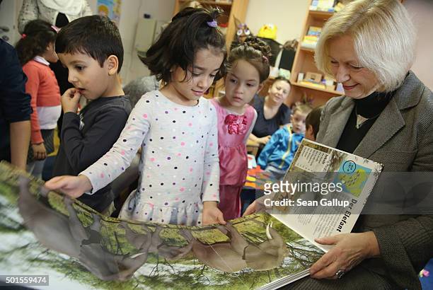German Education Minister Johanna Wanka shares a book about animals with Sahra from Afghanistan during the presentation of a new initiative to help...