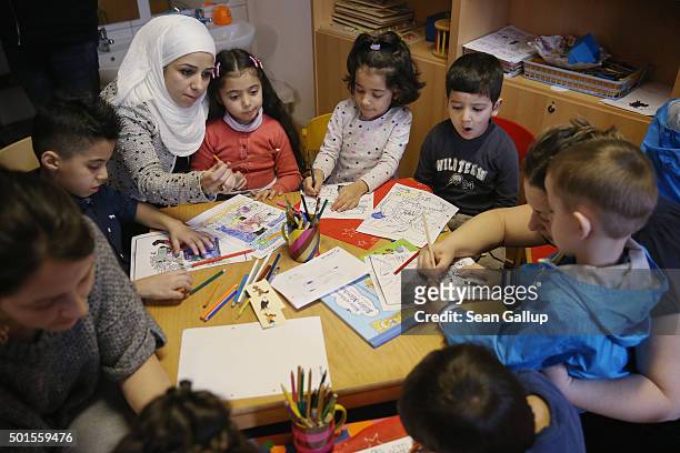 Immigrant mothers with their children look through games and books during the presentation of a new initiative to help children of refugees learn to...