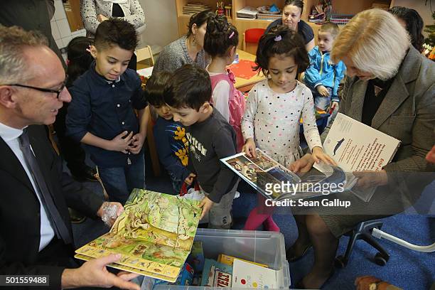 German Education Minister Johanna Wanka and Stiftung lesen foundation head Joerg Maas share games and books with immigrant children during the...