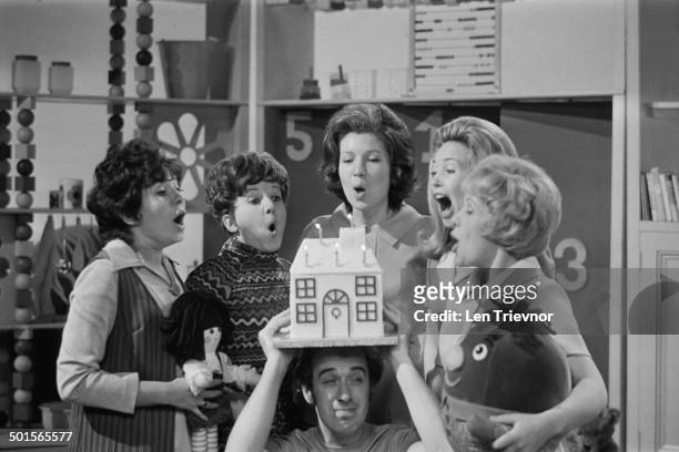 Presenter Rick Jones holds a birthday cake as his fellow presenters blow out the candles to celebrate the fifth birthday of the BBC TV children's...