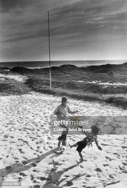 American actress Ali MacGraw and her son, Josh Evans, play together on the beach, California, 1978.