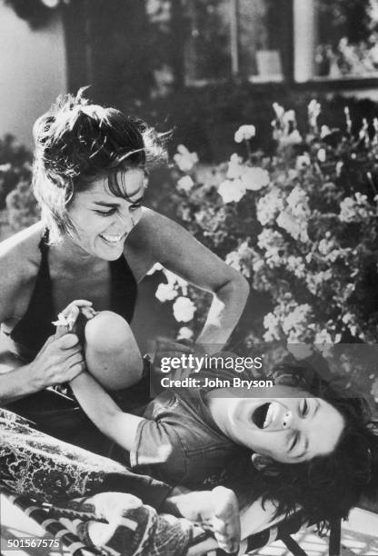 American actress Ali MacGraw tickles her son, Josh Evans, California, 1978.