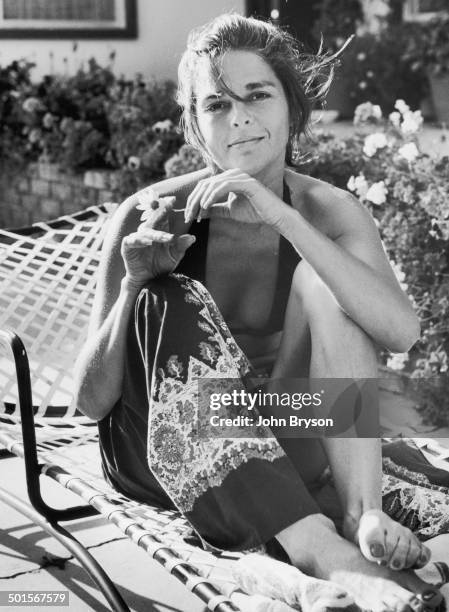 Portrait of American actress Ali MacGraw as she sits in deckchair, California, 1978.