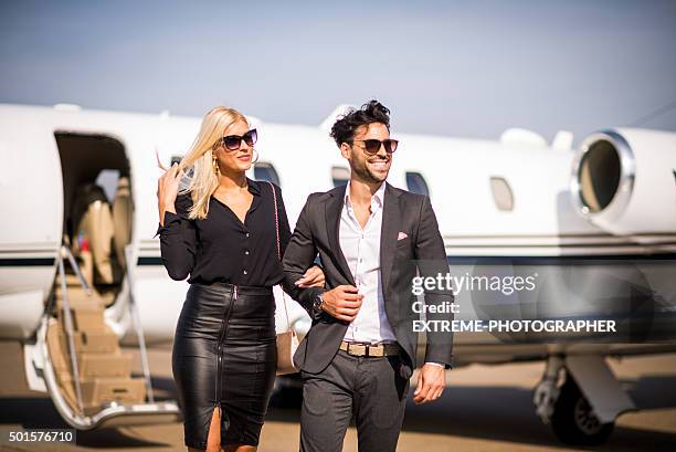 business couple leaving private aeroplane in the background - wingwalking stock pictures, royalty-free photos & images