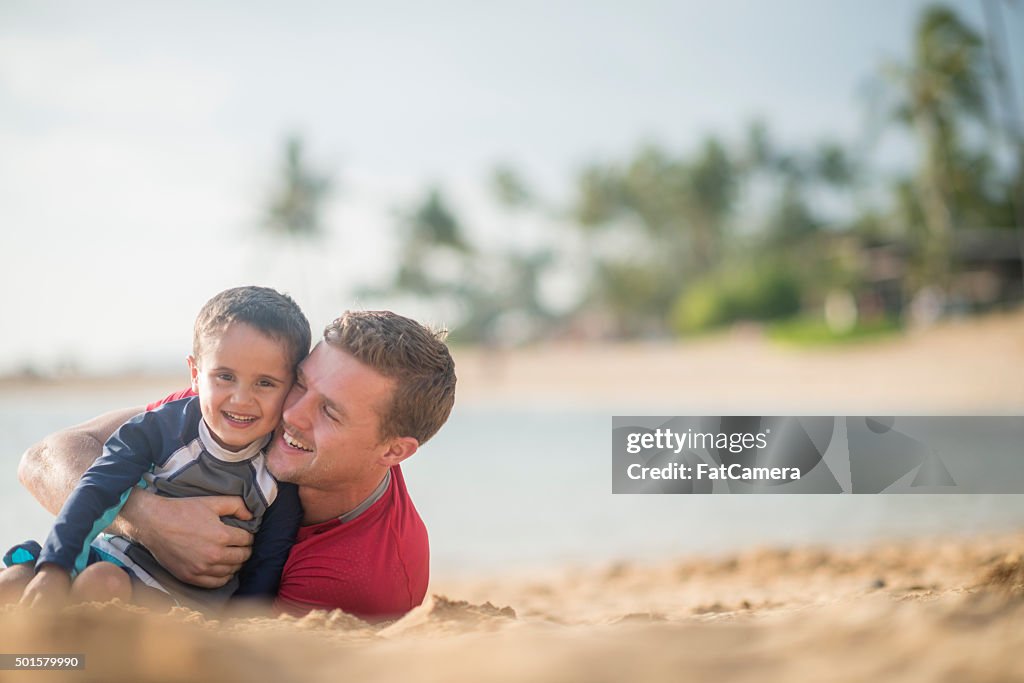 Father and Son Rolling in the Sand