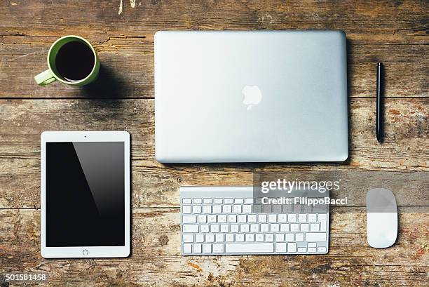 desktop essentials on wooden table - macbook business stockfoto's en -beelden