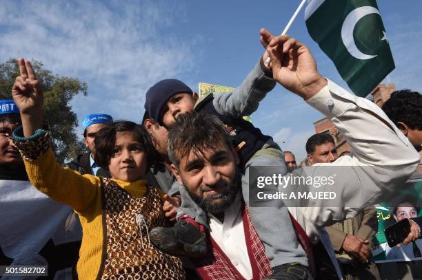 Activist of Tehreek Jawanan Pakistan wave flags as they march in Peshawar on December 16 on the first anniversary of an attack on Army Public School....