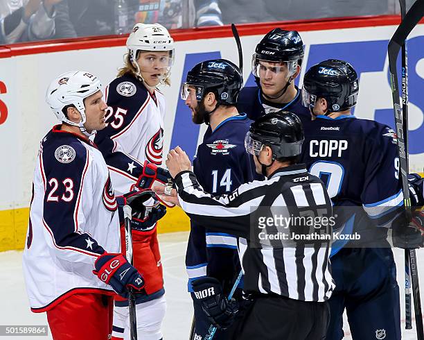 Linesman Derek Amell gets between David Clarkson of the Columbus Blue Jackets and Anthony Peluso of the Winnipeg Jets during a third period exchange...