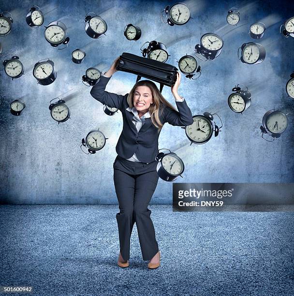 businesswoman using briefcase to protect himaself from flying clocks - ducking stock pictures, royalty-free photos & images