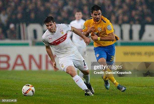 Emiliano Insua of Stuttgart is challenged by Gerrit Holtmann of Braunschweig during the round of sixteen DFB Cup match between VfB Stuttgart and...