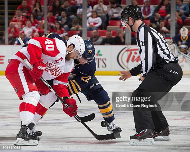 Linesman Devin Berg drops the puck between Henrik Zetterberg of the Detroit Red Wings and Johan Larsson of the Buffalo Sabres during an NHL game at...
