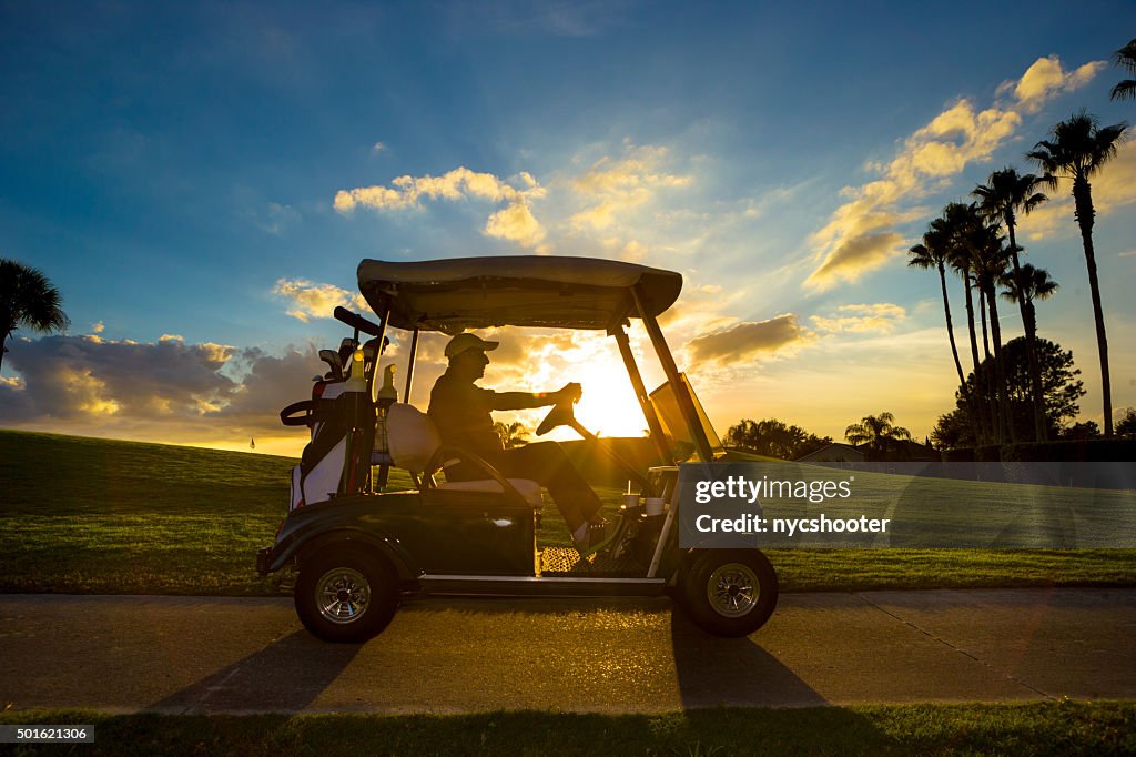 Senior golfer driving golf cart