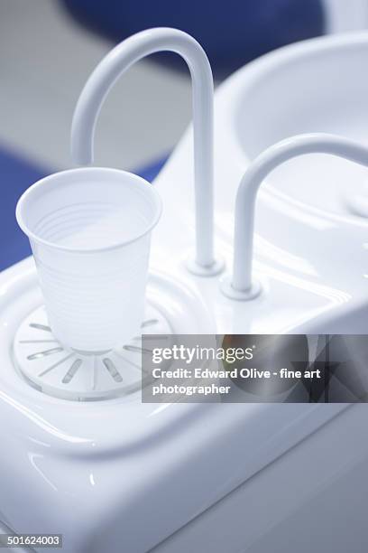 plastic cup and water fountain in dental clinic - dentistas stockfoto's en -beelden