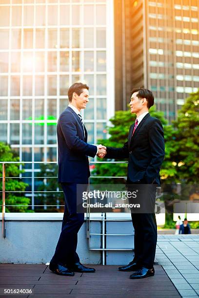 japanese business people warmly greating. - asian shaking hands stockfoto's en -beelden