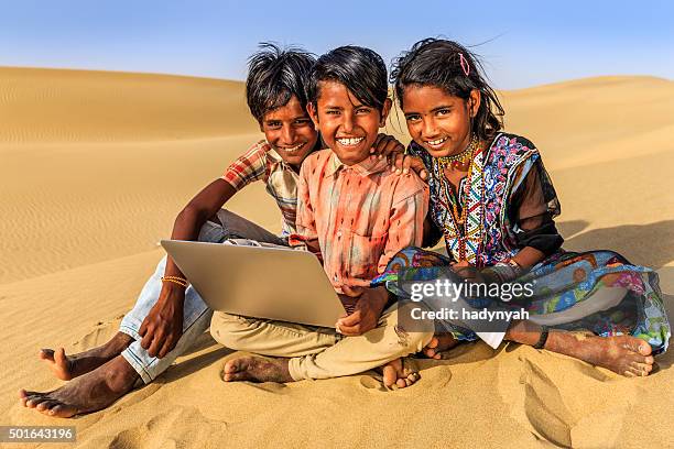 happy indian children using laptop, desert village, india - laptop desert stock pictures, royalty-free photos & images