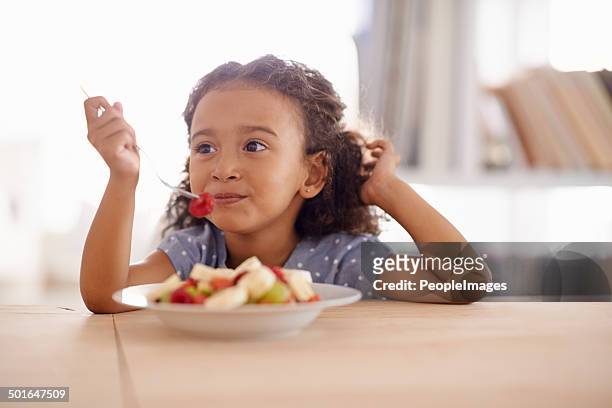 everything good for a growing child - child eating a fruit stockfoto's en -beelden