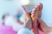 Therapist's hands massaging female foot