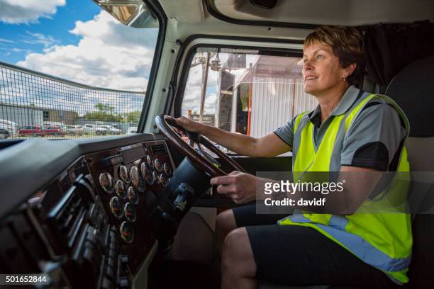 happy woman driving a truck wearing hi-vis clothes - förare yrke bildbanksfoton och bilder