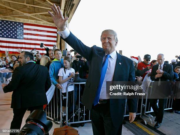 Republican presidential candidate Donald Trump waves to the crowd as he arrives at a campaign event at the International Air Response facility on...