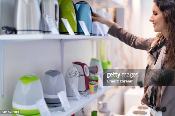 choosing new kettle - elektromarkt stockfoto's en -beelden