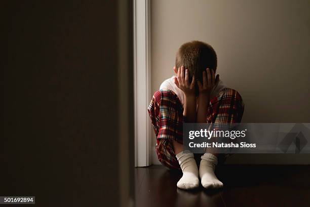 young boy in pajamas sitting in the hallway - hugging knees stock pictures, royalty-free photos & images