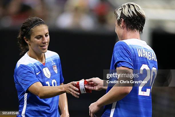 Abby Wambach hands the Captain's armband to Carli Lloyd of the United States as she leaves the field for the final time in her career during the...