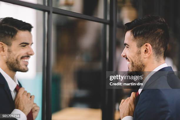 businessman getting dressed in front of the mirror - suave bildbanksfoton och bilder