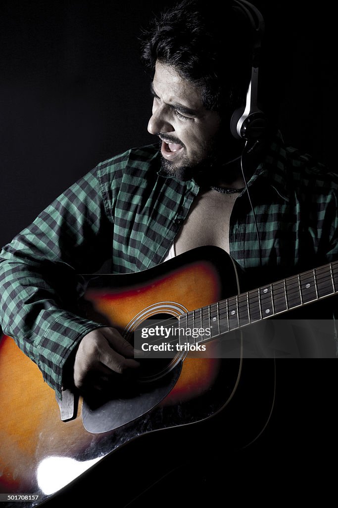 Male singer playing guitar