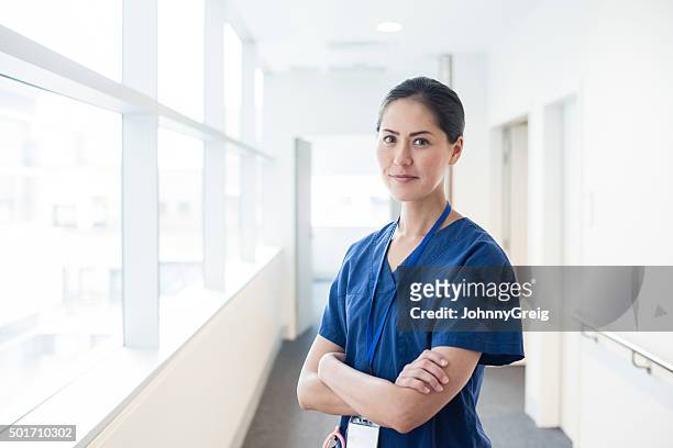 chino mujer médico en hospital corredor con brazos doblado, de retratos - vestimenta de hospital fotografías e imágenes de stock