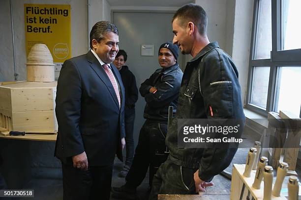 German Vice Chancellor and Economy and Energy Minister Sigmar Gabriel chats with two immigrants from Kosovo participating in the cabinet-making...