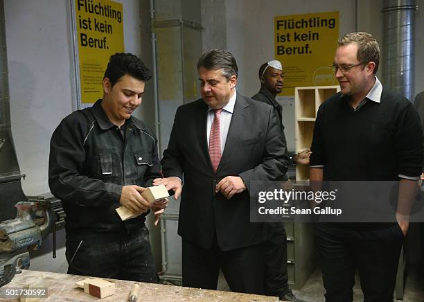 German Vice Chancellor and Economy and Energy Minister Sigmar Gabriel chats with a refugee from Syria participating in the cabinet-making tradecrafts...