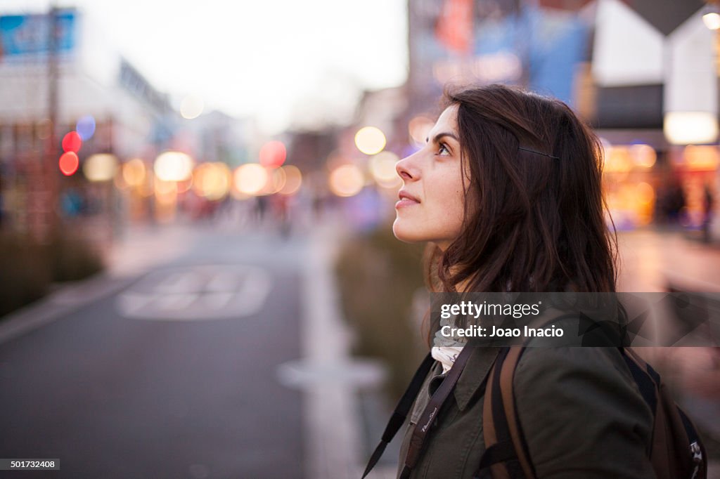 Young woman looking upwards at Cuba Street, Wellington, New Zealand