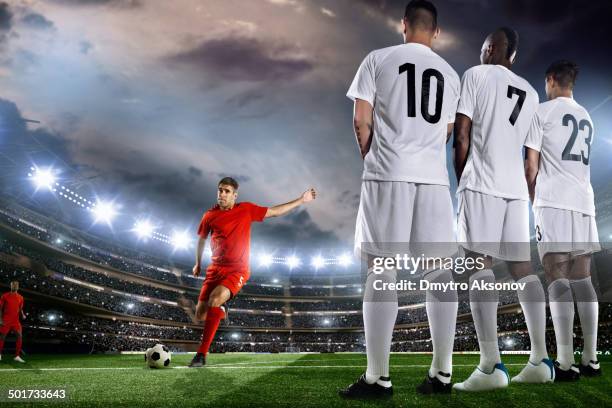 joueur de football de coups de pied un ballon devant un mur - coup franc photos et images de collection