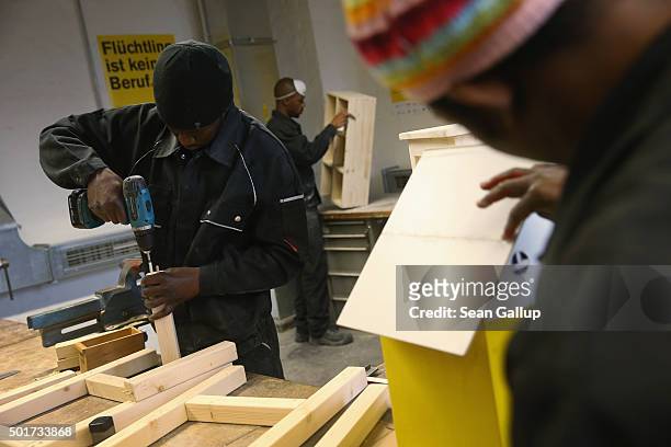 Asylum-applicants from Africa participate in the cabinet-making tradecrafts exposure program at the Arrivo center on December 17, 2015 in Berlin,...