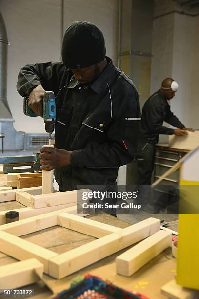 Asylum-applicants from Africa participate in the cabinet-making tradecrafts exposure program at the Arrivo center on December 17, 2015 in Berlin,...