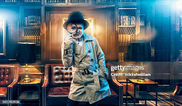kid detective wears trench coat and searches for clues - child discovering science stockfoto's en -beelden