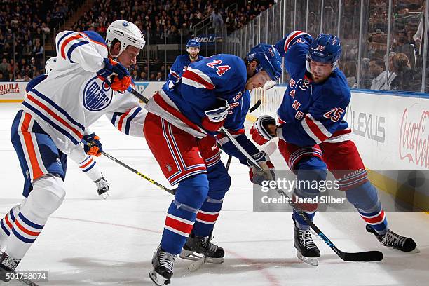 Oscar Lindberg and Viktor Stalberg of the New York Rangers battle for the puck against Nikita Nikitin of the Edmonton Oilers at Madison Square Garden...