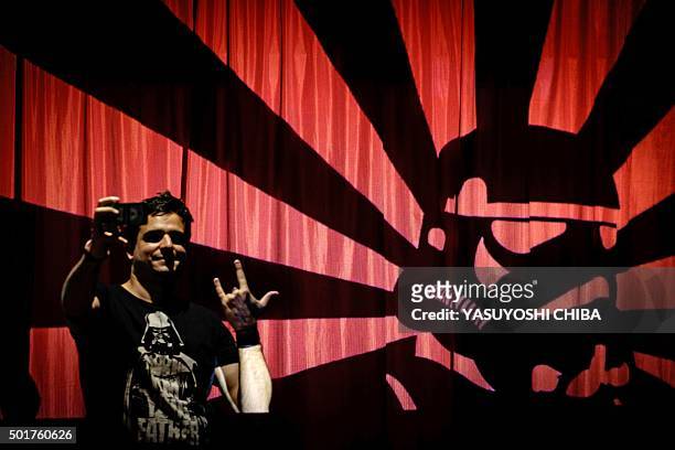 Fan takes a selfie with projected images of the film "Star Wars", during the opening of the Rio Mapping Festival 2015, on December 17 in Rio de...