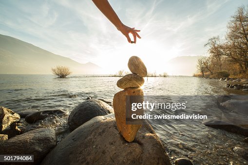 Stacking Rocks Pose Detail Of Person Stacking Rocks By The Lake High-Res Stock Photo ...