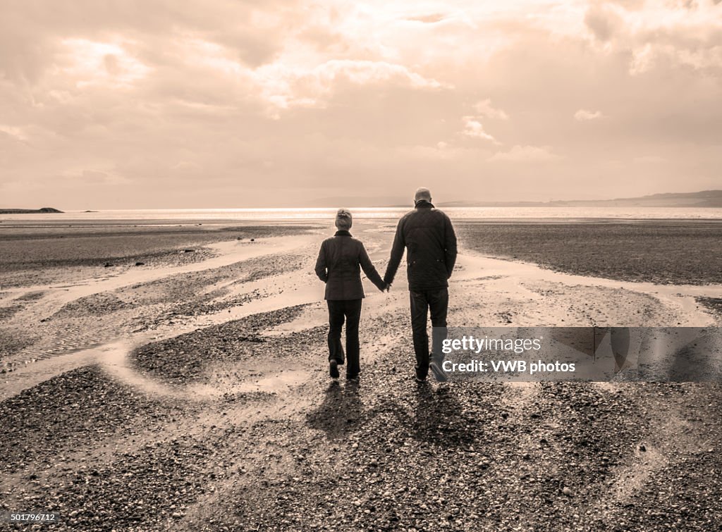 Couple Holding Hands, walking into the sunset. Isle of Bute
