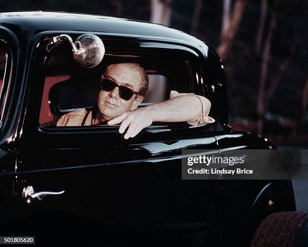 Painter and cartoonist Robert Williams in a hotrod in Timothy Leary's driveway in1995 in 1995 in Bevery Hills, California.