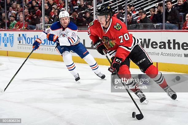 Dennis Rasmussen of the Chicago Blackhawks controls the puck ahead of Nikita Nikitin of the Edmonton Oilers in the first period of the NHL game at...