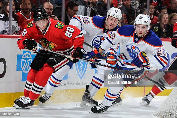 Patrick Kane of the Chicago Blackhawks leads Nikita Nikitin and Iiro Pakarinen of the Edmonton Oilers around the boards in the second period of the...