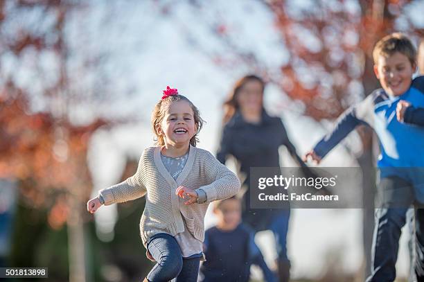 familie läuft an einem herbsttag im - fangspiel stock-fotos und bilder