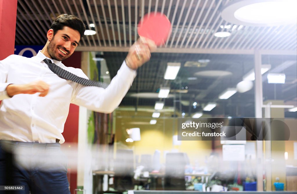 Young business man relaxing with playing ping pong