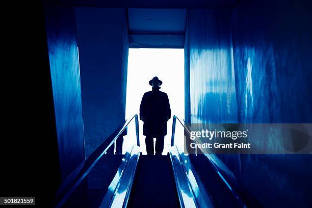 man in dark hat and coat taking elevator - stranger danger stock pictures, royalty-free photos & images