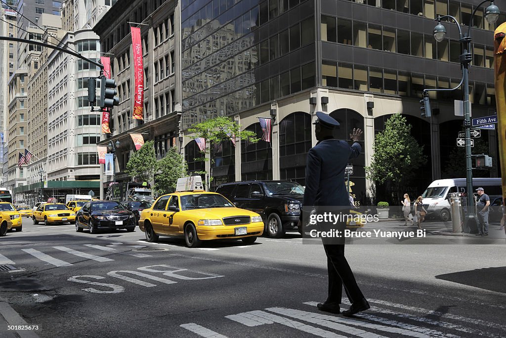 Doorman flagging down a taxi cab