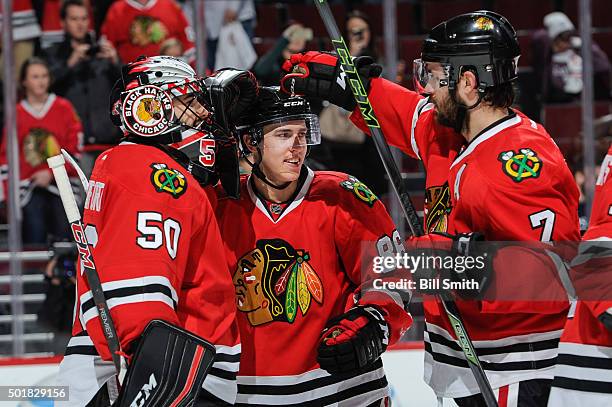 Teuvo Teravainen of the Chicago Blackhawks celebrates with goalie Corey Crawford and Brent Seabrook after being named the number one player of the...